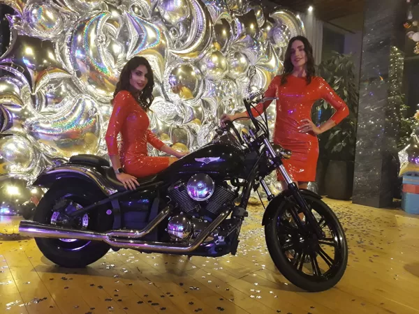 Черный Harley-Davidson и хостес девушки в красном, идеальное сочетание 
